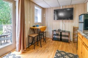 a living room with a table and a tv and a bar at Cozy Hiwassee Vacation Rental with Yard in Hiwassee