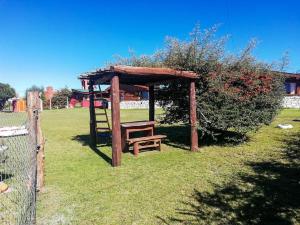 una mesa de picnic de madera y un banco en un parque en cabañas santa catalina en Villa Giardino
