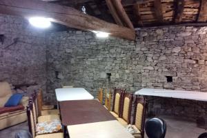 a room with a stone wall and a table and chairs at Casa rural a las afueras de Gijón in Gijón