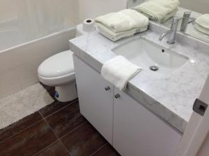 y baño con lavabo blanco y aseo. en DEPARTAMENTO La PAZ De 2 HABITACIONES, en Lima