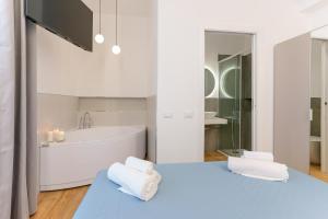 a white bathroom with a tub and a sink at Aqua Comfort Rooms - Eja Sardinia in Cagliari