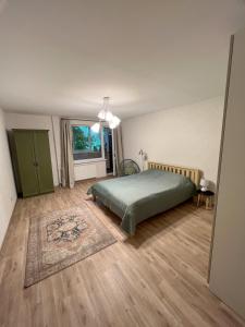 Un dormitorio con una cama verde y una ventana en Nauji, jaukūs apartamentai, en Klaipėda