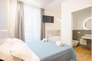 a bedroom with a bed and a tub and a sink at Aqua Comfort Rooms - Eja Sardinia in Cagliari