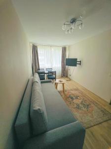 sala de estar con sofá y mesa en Nauji, jaukūs apartamentai, en Klaipėda