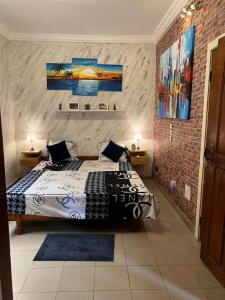 a bedroom with a bed and a brick wall at Holiday Appartment Elbe in Lomé