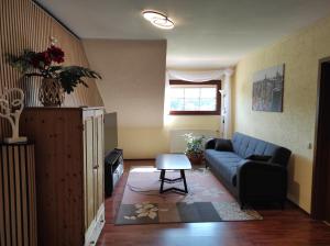 a living room with a blue couch and a table at Ferienwohnung am Zweitälerweg in Weiskirchen