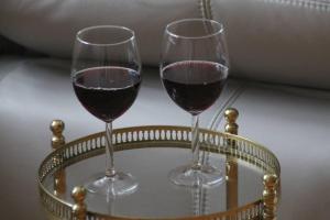 zwei Gläser Rotwein auf einem Glastisch in der Unterkunft Charmantes Bauernhaus-Cottage 
