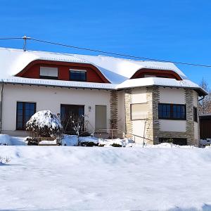 een huis met sneeuw op de grond ervoor bij Ferienwohnung am Zweitälerweg in Weiskirchen