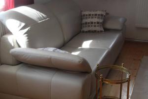um sofá de couro branco numa sala de estar em Charmantes Bauernhaus-Cottage 