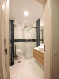 uma casa de banho com um chuveiro, um WC e um lavatório. em Sonetos - Guest House no Porto