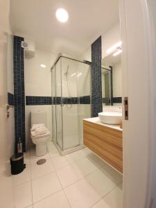 a bathroom with a shower and a toilet and a sink at Sonetos - Guest House in Porto