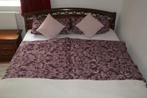 ein Bett mit einer braunen Decke und Kissen darauf in der Unterkunft Charmantes Bauernhaus-Cottage 