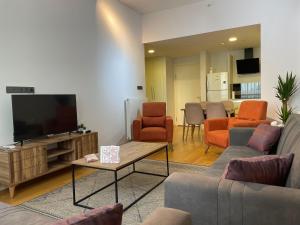 ein Wohnzimmer mit einem Sofa und einem TV in der Unterkunft Luxury Fully Furnished Apartment in Istanbul