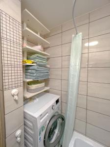 lavadero con lavadora en el baño en Nauji, jaukūs apartamentai, en Klaipėda