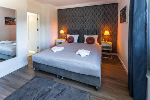 - une chambre avec un grand lit et 2 tables de chevet dans l'établissement Klif Resort Apartamenty, à Mechelinki