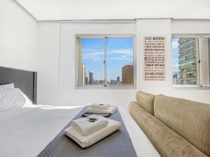 a white bedroom with a bed and a couch at Hotel na Vila Olimpia in São Paulo