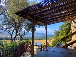 a wooden pergola with a table and chairs on a patio at BERGERIE A Murta, Domaine de l Ogliastru in Olmeto