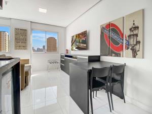 a kitchen with a black counter and chairs at Hotel na Vila Olimpia in São Paulo