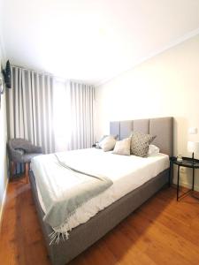1 dormitorio con 1 cama grande con sábanas blancas en Sonetos - Guest House, en Oporto