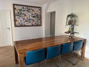 einem Esstisch mit blauen Stühlen und einem Gemälde in der Unterkunft Ferienwohnung „Haus Herbert“ Wohnung „Emma“ 