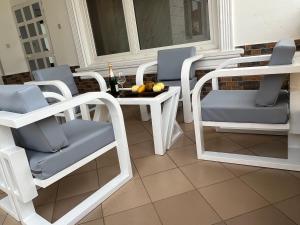 ロメにあるHoliday Appartment Elbeの白い椅子とテーブル、窓のあるポーチ