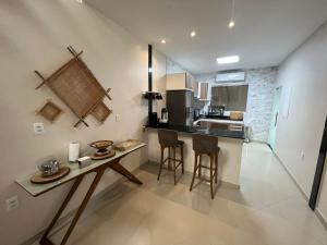 a kitchen with a table and two bar stools at River X House in Manaus