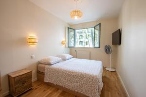 Schlafzimmer mit einem Bett und einem Fenster in der Unterkunft LuxeZen - SPA in Villeurbanne