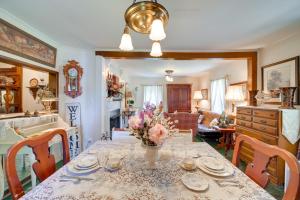 una mesa de comedor con un jarrón de flores. en Historic Fort Smith Cottage Less Than 1 Mi to Downtown! en Fort Smith