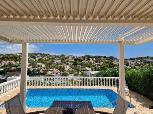 a patio with a swimming pool and a white pergola at Renovierte Villa mit privatem Pool fußläufig zum Meer in Benissa +24 photos