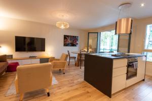 a kitchen and living room with a table and chairs at LuxeZen - SPA in Villeurbanne