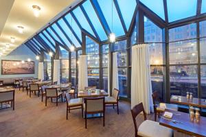 - un restaurant avec des tables, des chaises et de grandes fenêtres dans l'établissement Capital Hilton, à Washington