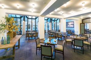 un restaurant avec des tables, des chaises et des fenêtres dans l'établissement Capital Hilton, à Washington
