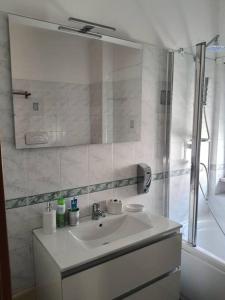 een badkamer met een wastafel en een douche met een spiegel bij Casa Vacanze Carlà Formia in Formia