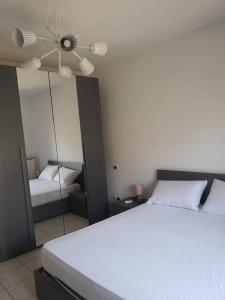 een slaapkamer met een wit bed en een spiegel bij Casa Vacanze Carlà Formia in Formia