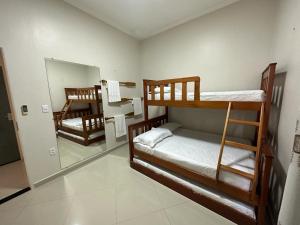 a room with two bunk beds and a mirror at River X House in Manaus