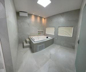 a white bathroom with a tub and a sink at River X House in Manaus