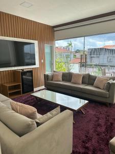 sala de estar con sofá y mesa de cristal en River X House en Manaus