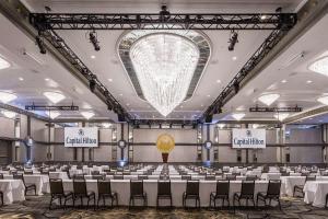 a large banquet hall with white tables and chairs at Capital Hilton in Washington