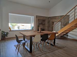 uma sala de jantar com uma mesa de madeira e cadeiras em Casa do Sobrado ByAlta 