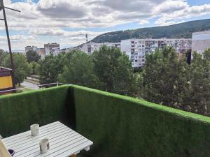 a balcony with a table and a view of a city at Alexander Apartments Kyustendil in Kyustendil
