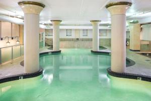 Embassy Suites by Hilton Portland Downtown في بورتلاند: مسبح فيه اعمده وماء اخضر في مبنى