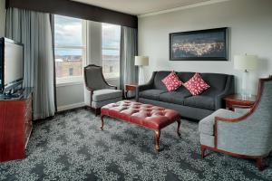 a living room with a couch and chairs and a television at Embassy Suites by Hilton Portland Downtown in Portland