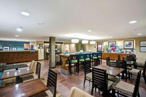 a restaurant with tables and chairs and a bar at Hampton Inn by Hilton Milford in Milford