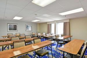 an empty classroom with wooden tables and chairs at Hampton Inn by Hilton Milford in Milford
