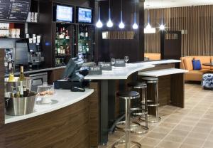 a bar in a restaurant with stools at a counter at Courtyard by Marriott Houston North/Shenandoah in The Woodlands