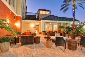 een patio met stoelen en tafels voor een gebouw bij Hilton Garden Inn Tampa Northwest/Oldsmar in Oldsmar