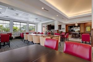 uma sala de jantar com mesas e cadeiras vermelhas em Hilton Garden Inn Tampa Northwest/Oldsmar em Oldsmar