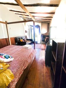 a bedroom with a bed and a wooden floor at Wolf Totem Steam Punk Loft Villa in Pisac