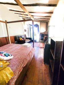 ein Schlafzimmer mit einem Bett und einem Holzboden in der Unterkunft Wolf Totem Backpacker Steam Punk Villa in Pisac