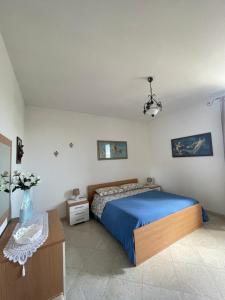 um quarto com uma cama com uma colcha azul em Bilocale al centro del Salento em Muro Leccese